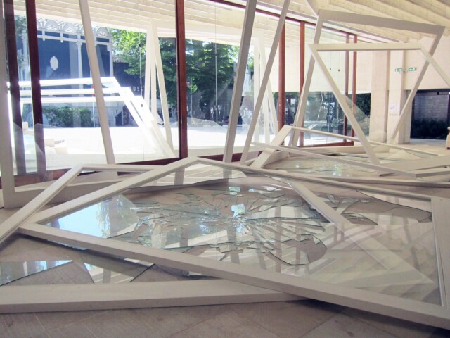 Kuvassa installaatio, jossa ikkunoita on kaatunut ja mennyt rikki